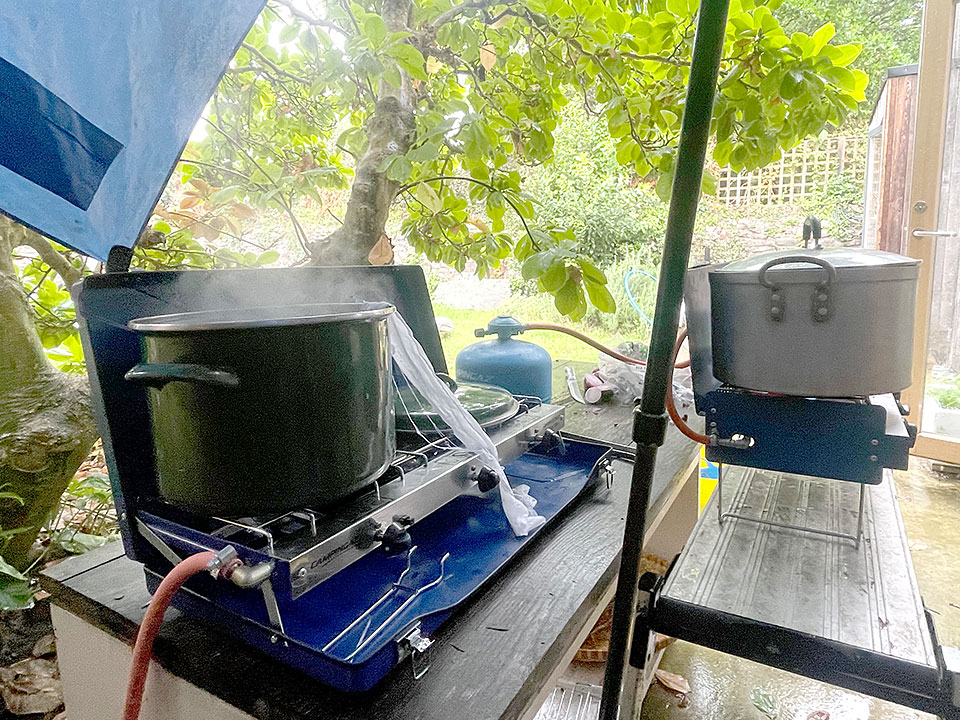 Pots of dye heating on camping stoves